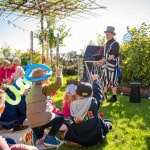 Kinderzauberer Michael zaubert in einem Garten auf der Wiese