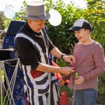 Kinderzauberer Michael zaubert mit einem Kind zusammen. Das Kind lacht dabei