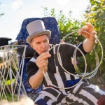 Zaubertricks mit großen silbernen Ringen. Kinderzauberer Michael in Aktion bei einem Kindergeburtstag. Dem Zauberer sieht man den Spaß an.
