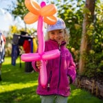 Mädchen zeigt eine Ballonblume. Die Blume würde gefertigt von Ballonkünstler Michael